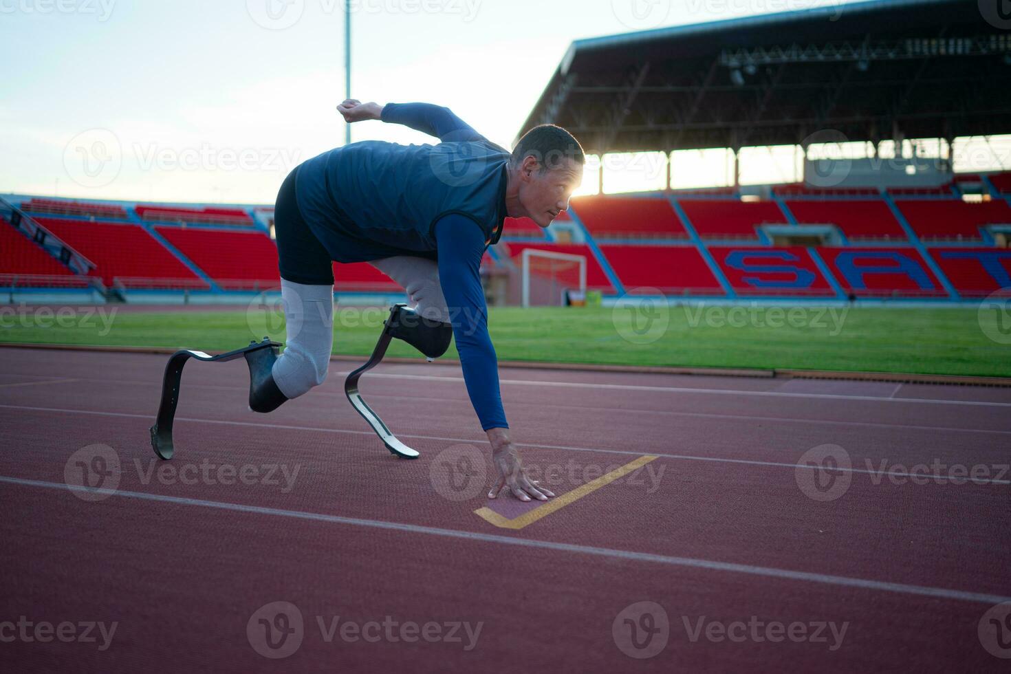 Disabled athletes prepare in starting position ready to run on stadium track photo