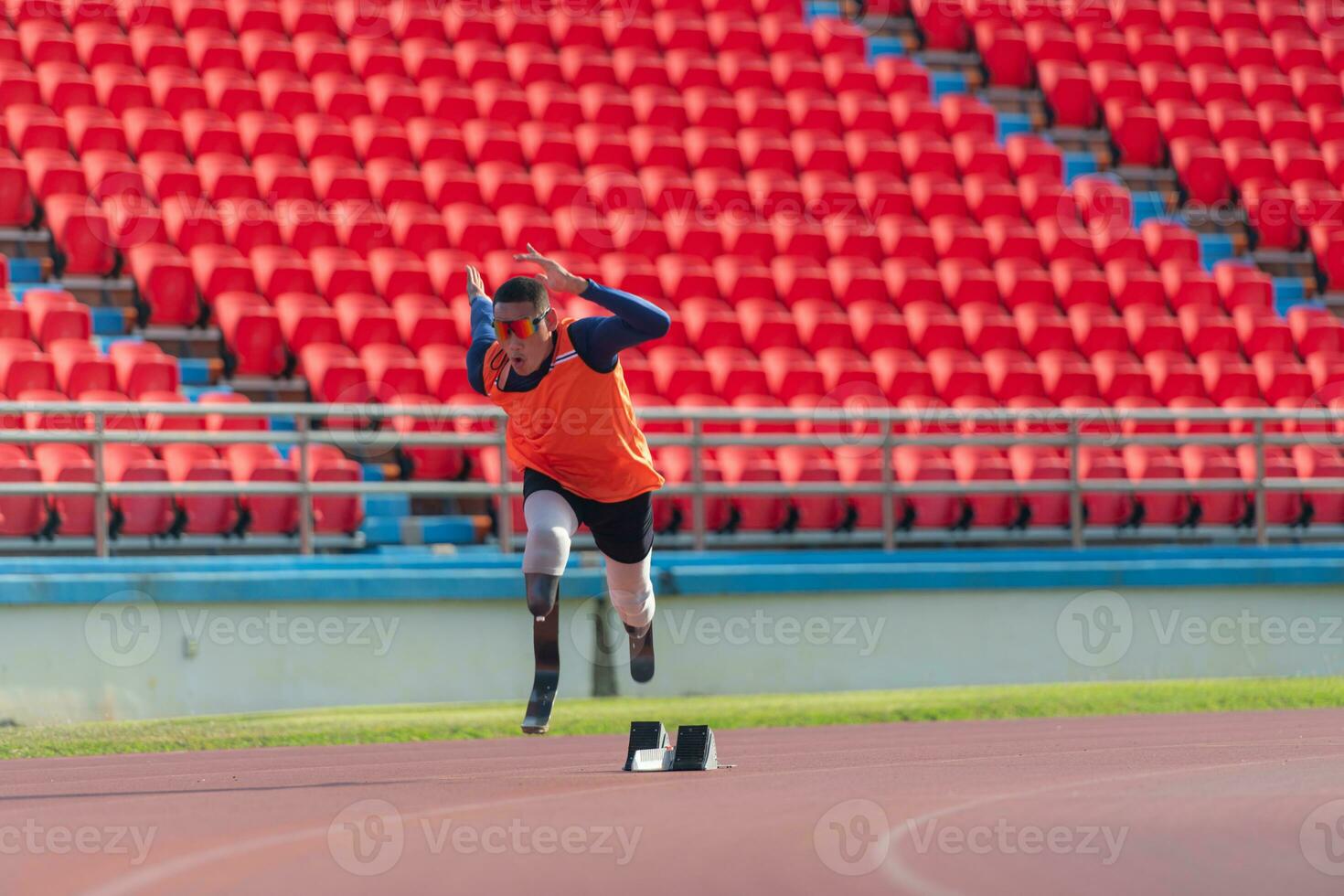 Disabled athletes prepare in starting position ready to run on stadium track photo