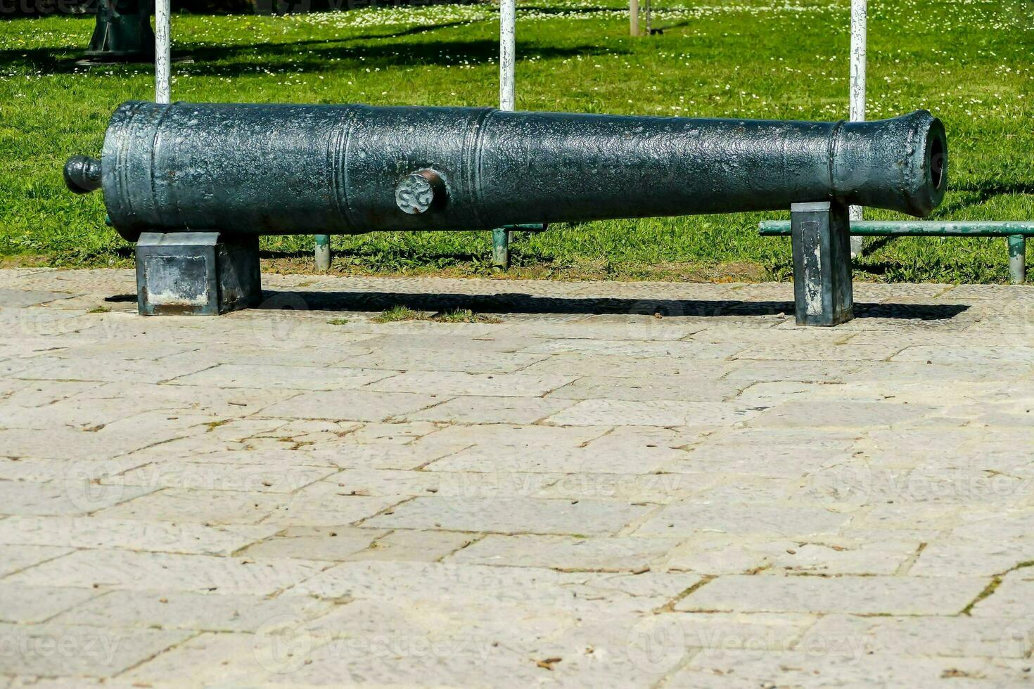 a cannon on the ground in front of a park photo