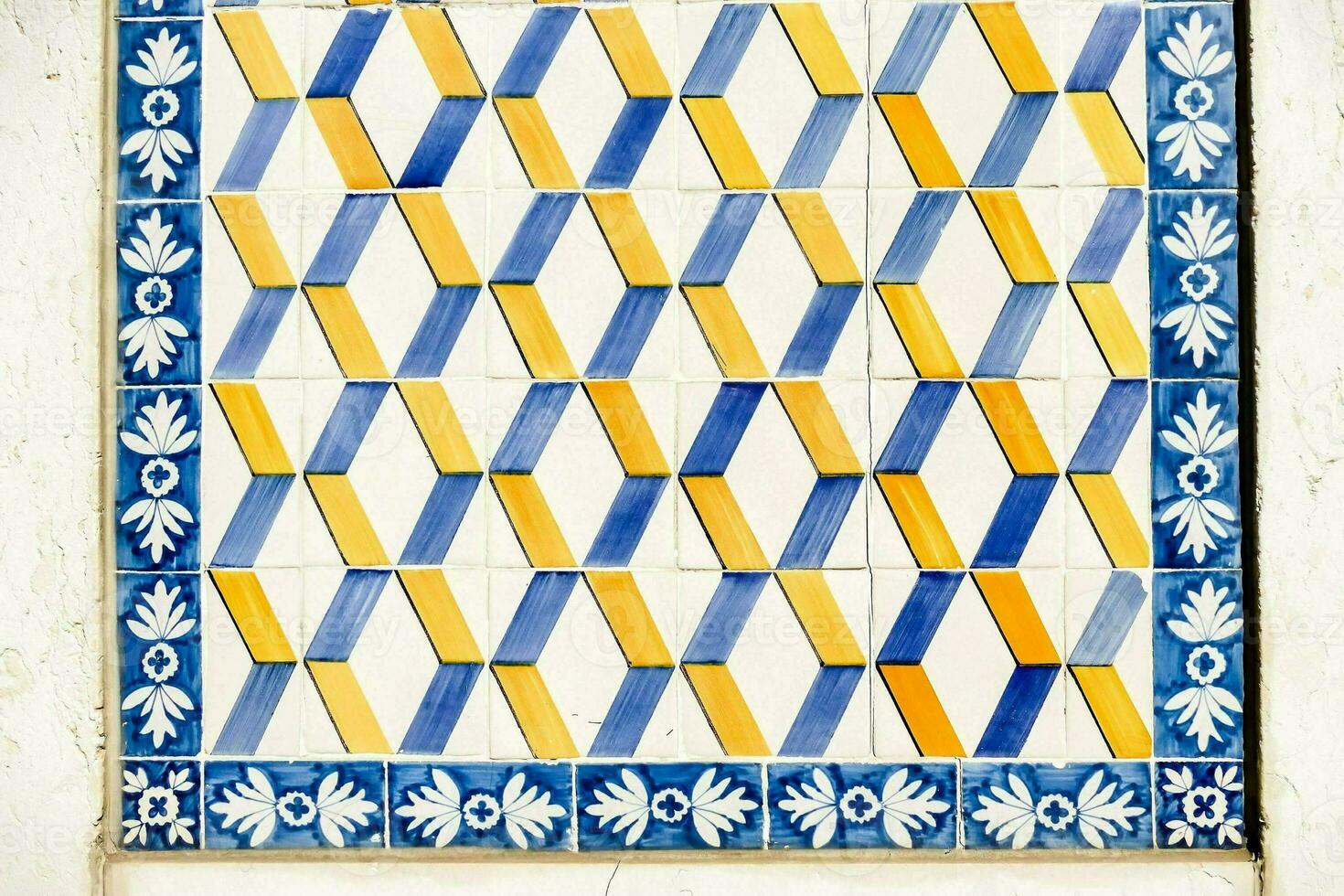 a blue and yellow tile with a pattern photo