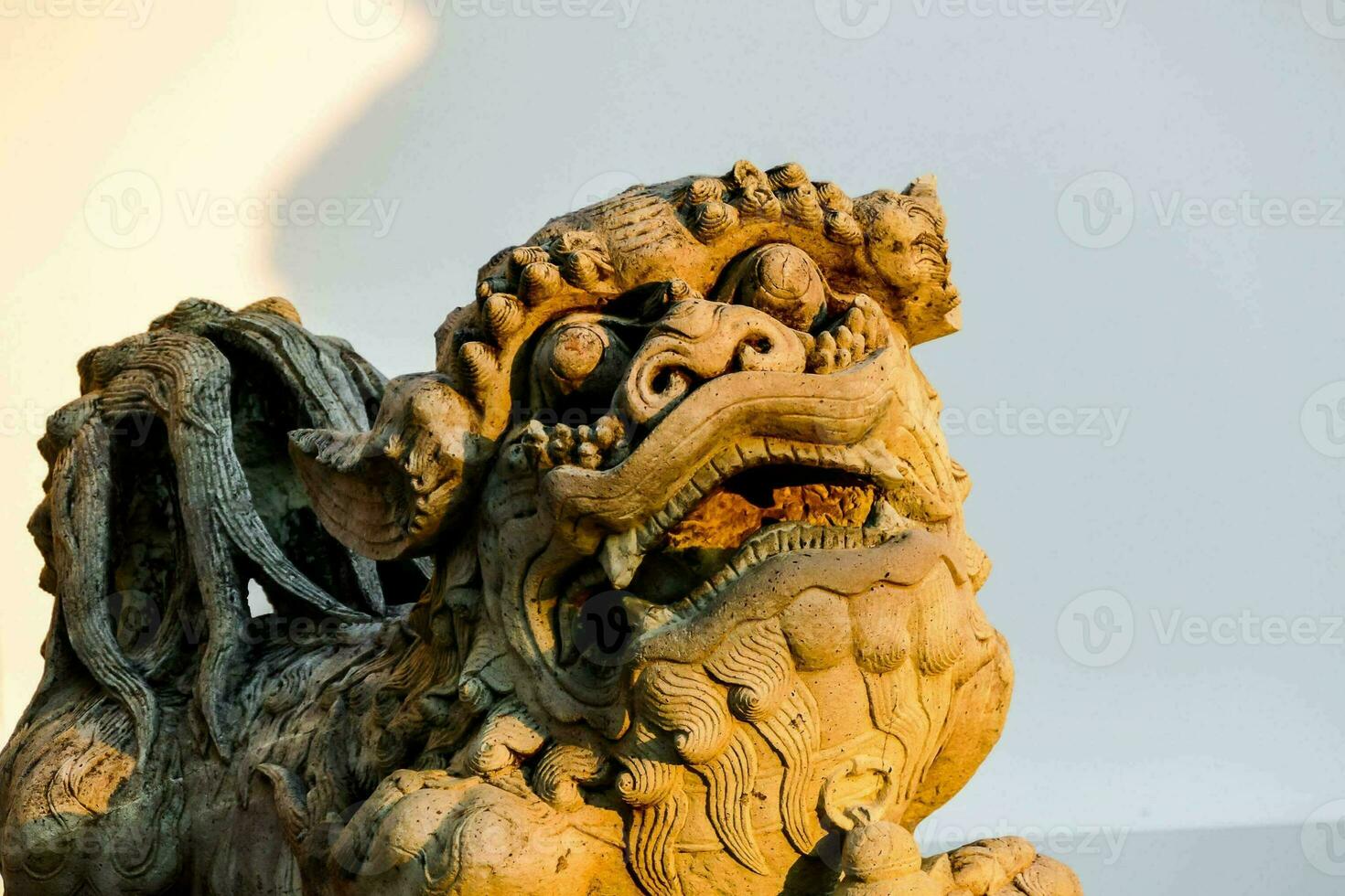 a statue of a chinese lion with its mouth open photo