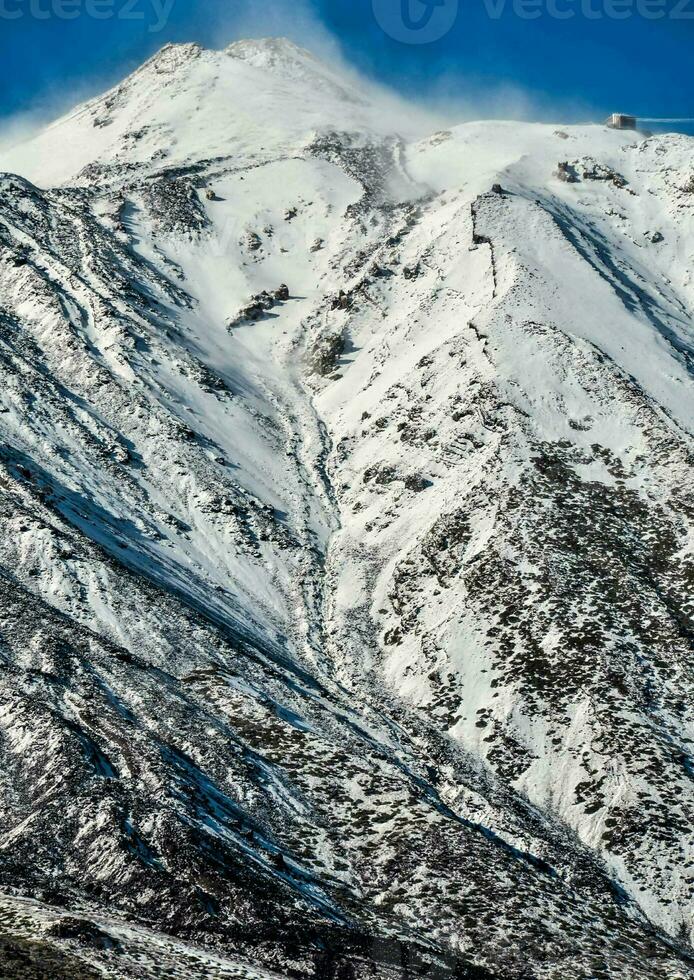 a snow covered mountain with a blue sky photo