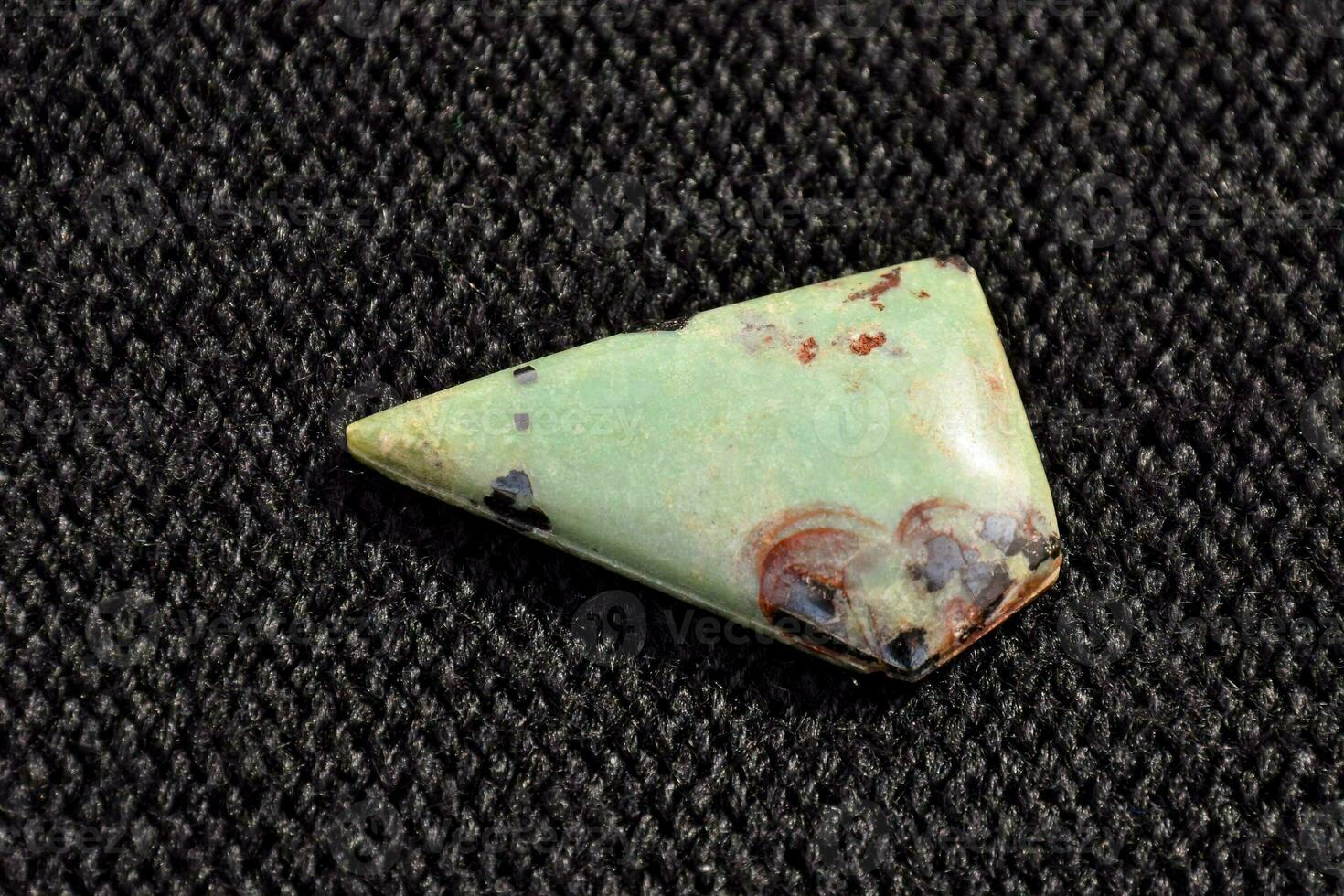 a green and red stone with a triangular shape photo