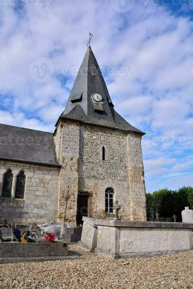 a church with a clock tower and a graveyard photo