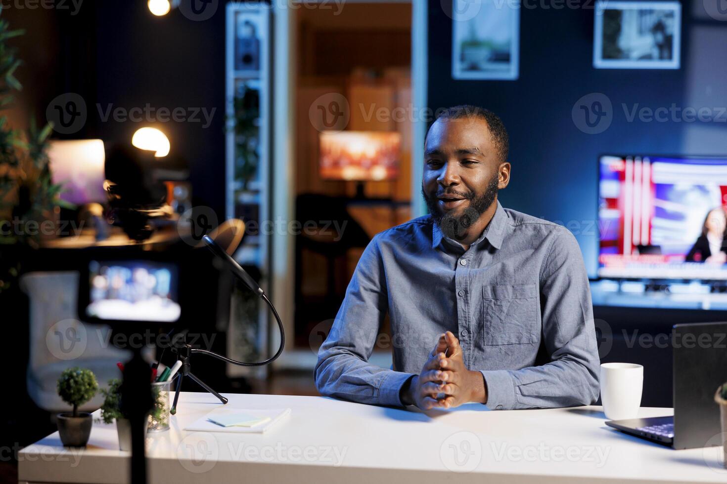 African american streamer doing live broadcast talking to audience about recent news headlines. Internet show host talking with viewers, presenting information in entertaining manner photo