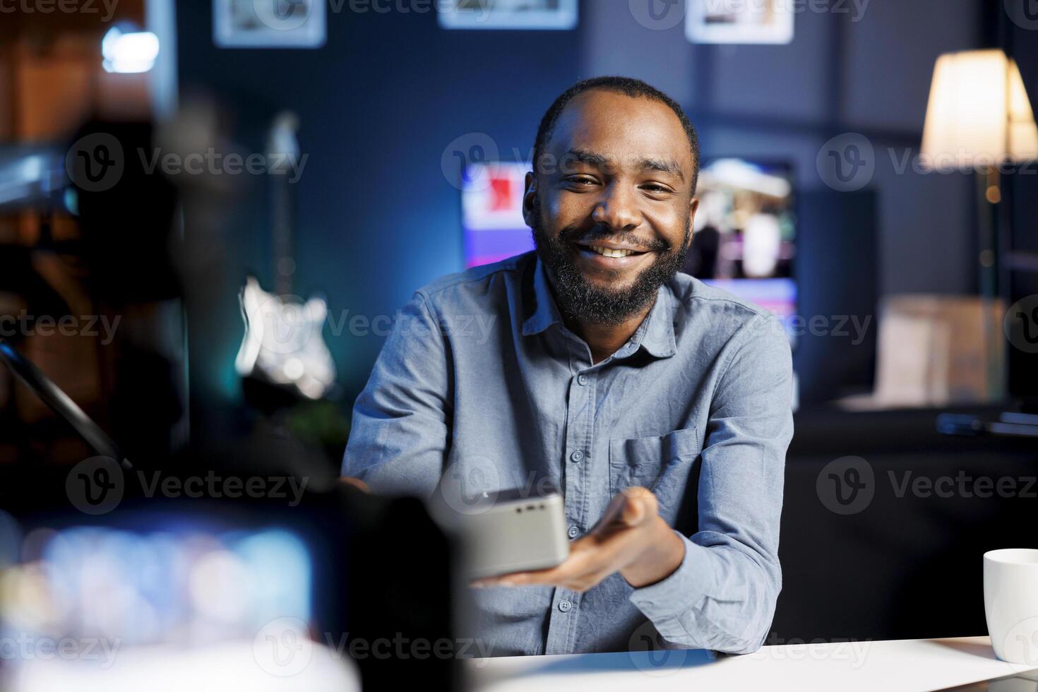 African american audio engineer assessing portable speaker, showing dissatisfaction with subpar materials used. Internet show host displeased with low quality wireless music playing device photo