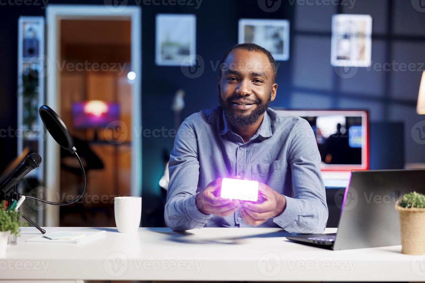 Smiling tech influencer filming brand sponsored mini RGB lights device unpacking, presenting info to audience. Media star showing helpful broadcast production tool to subscribers from personal studio photo