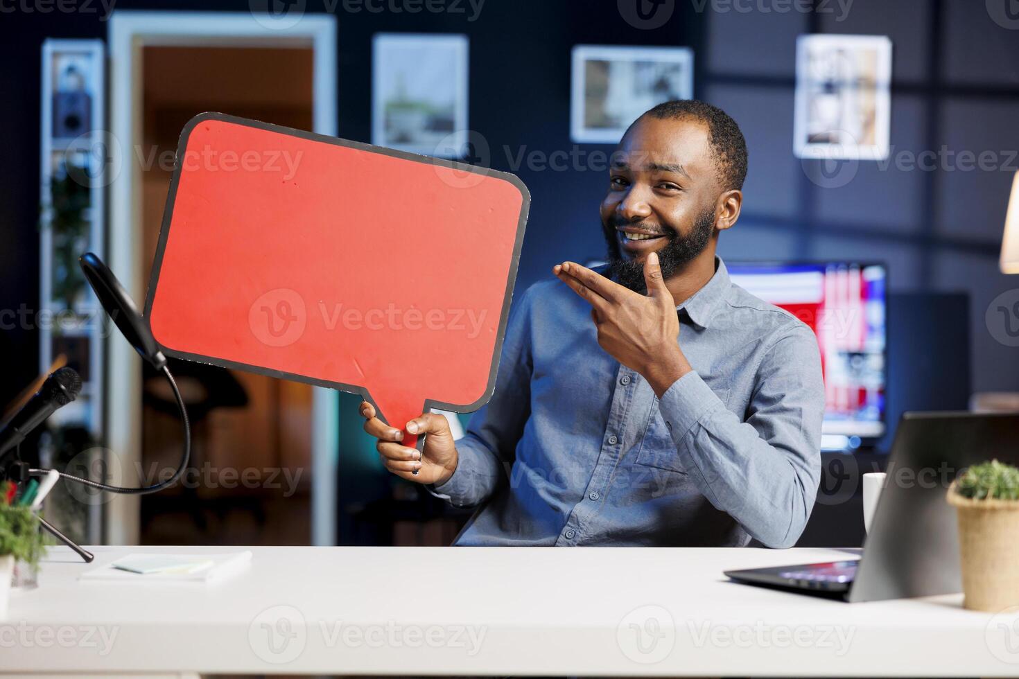 Happy man comissioned by brand to film sponsored content, holding empty copy space sign in hand, talking to audience. Trending media star using cardboard bubble speech cutout to do promotion to fans photo