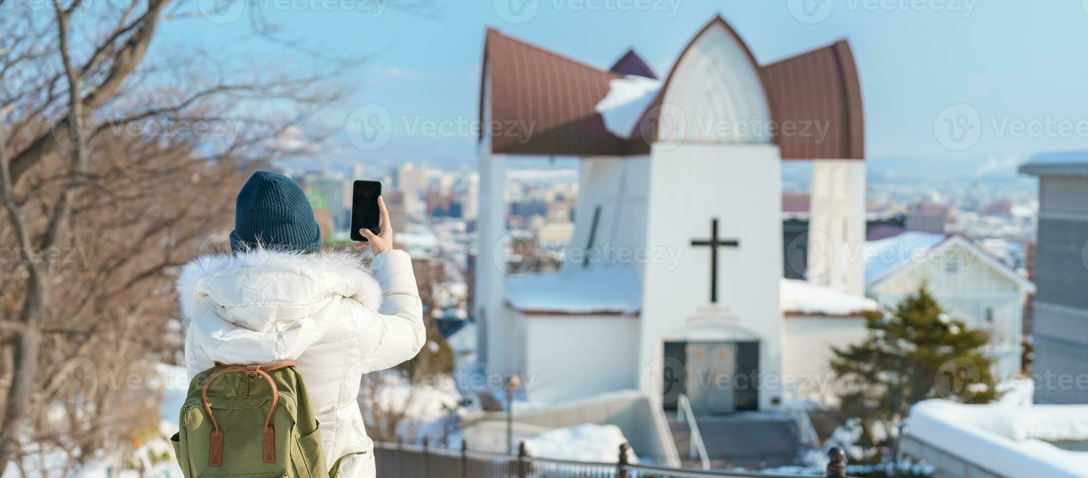 Woman tourist Visiting in Hakodate, Traveler in Sweater sightseeing Episcopal Church with Snow in winter. landmark and popular for attractions in Hokkaido, Japan. Travel and Vacation concept photo