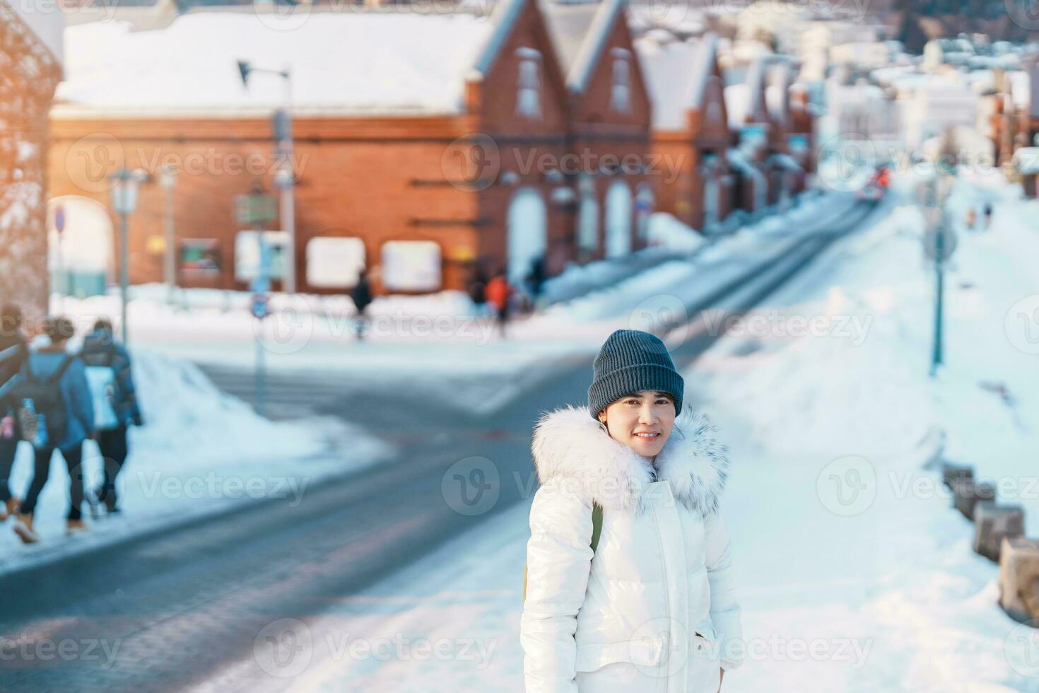 Woman tourist Visiting in Hakodate, Traveler in Sweater sightseeing Kanemori Red Brick Warehouse with Snow in winter. landmark and popular for attractions in Hokkaido,Japan.Travel and Vacation concept photo