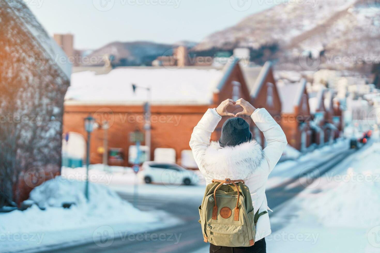 Woman tourist Visiting in Hakodate, Traveler in Sweater sightseeing Kanemori Red Brick Warehouse with Snow in winter. landmark and popular for attractions in Hokkaido,Japan.Travel and Vacation concept photo