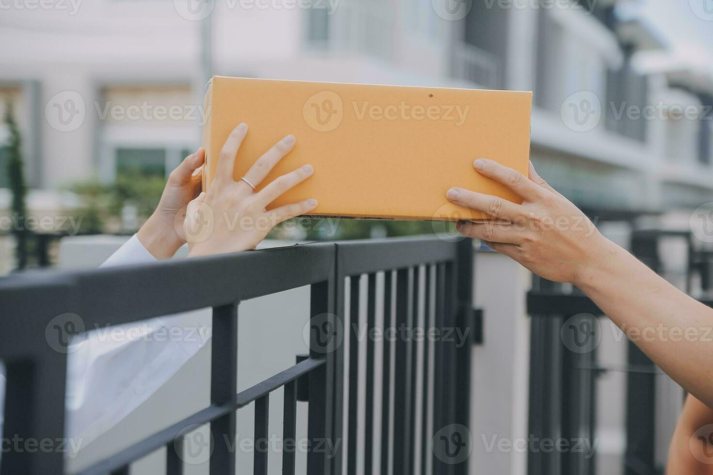 Asian Woman Receiving Product from delivery man at Home, Young Owner Woman Order Product from Smartphone Application, Woman with Online Business or SME Concept. photo