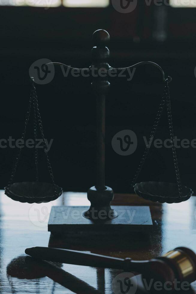 Justice and law concept.Male judge in a courtroom with the gavel, working with, computer and docking keyboard, eyeglasses, on table in morning light photo