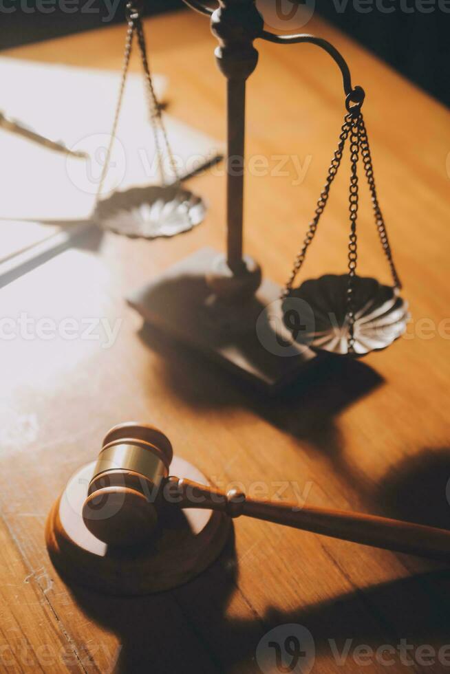 Business and lawyers discussing contract papers with brass scale on desk in office. Law, legal services, advice, justice and law concept picture with film grain effect photo