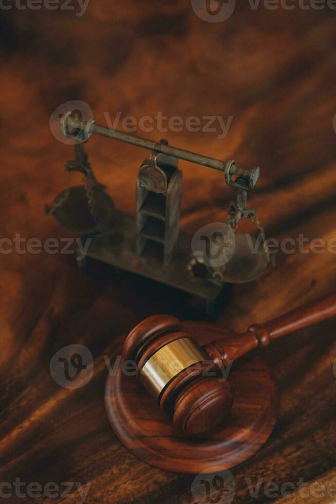 law books and scales of justice on desk in library of law firm. jurisprudence legal education concept. photo