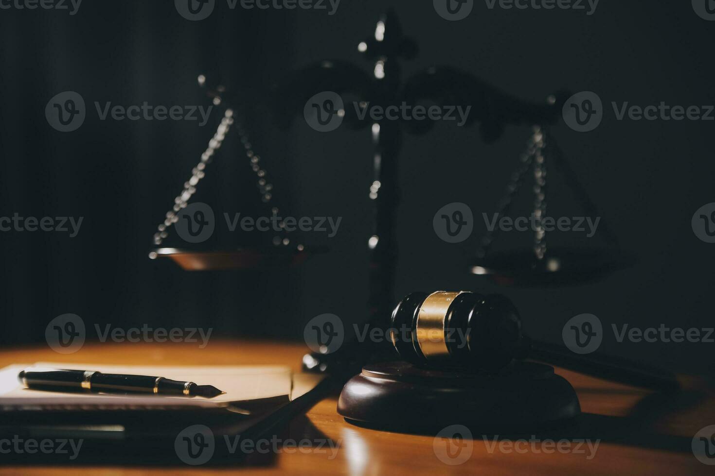 law books and scales of justice on desk in library of law firm. jurisprudence legal education concept. photo