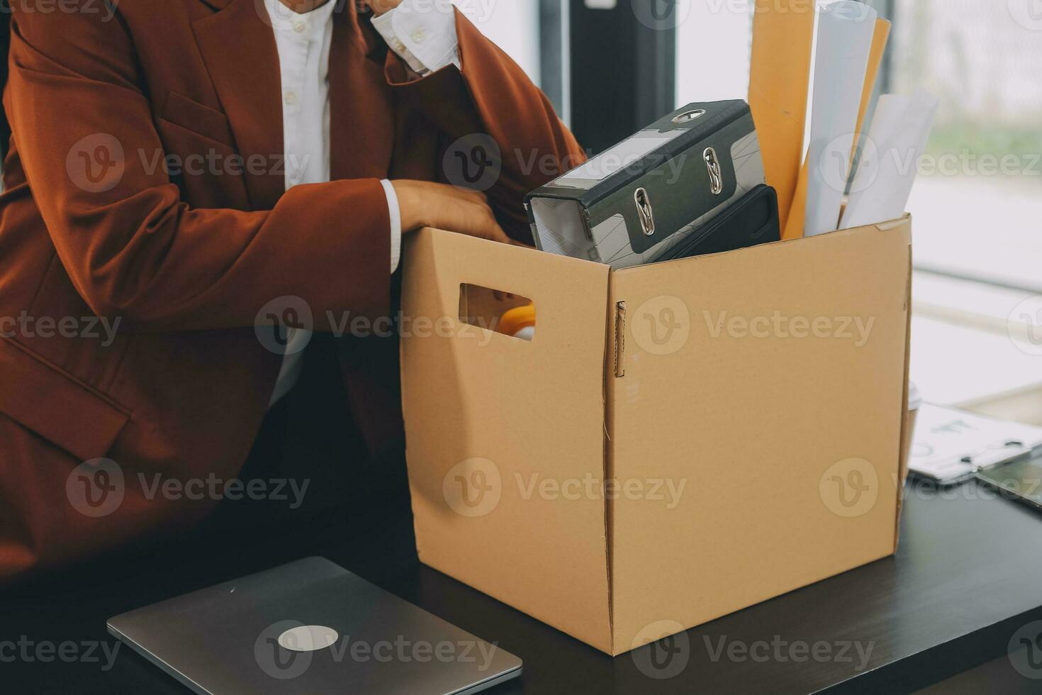 Business man employee stressful resignation from job while picking up personal belongings into brown cardboard box and carrying to walking out from office photo