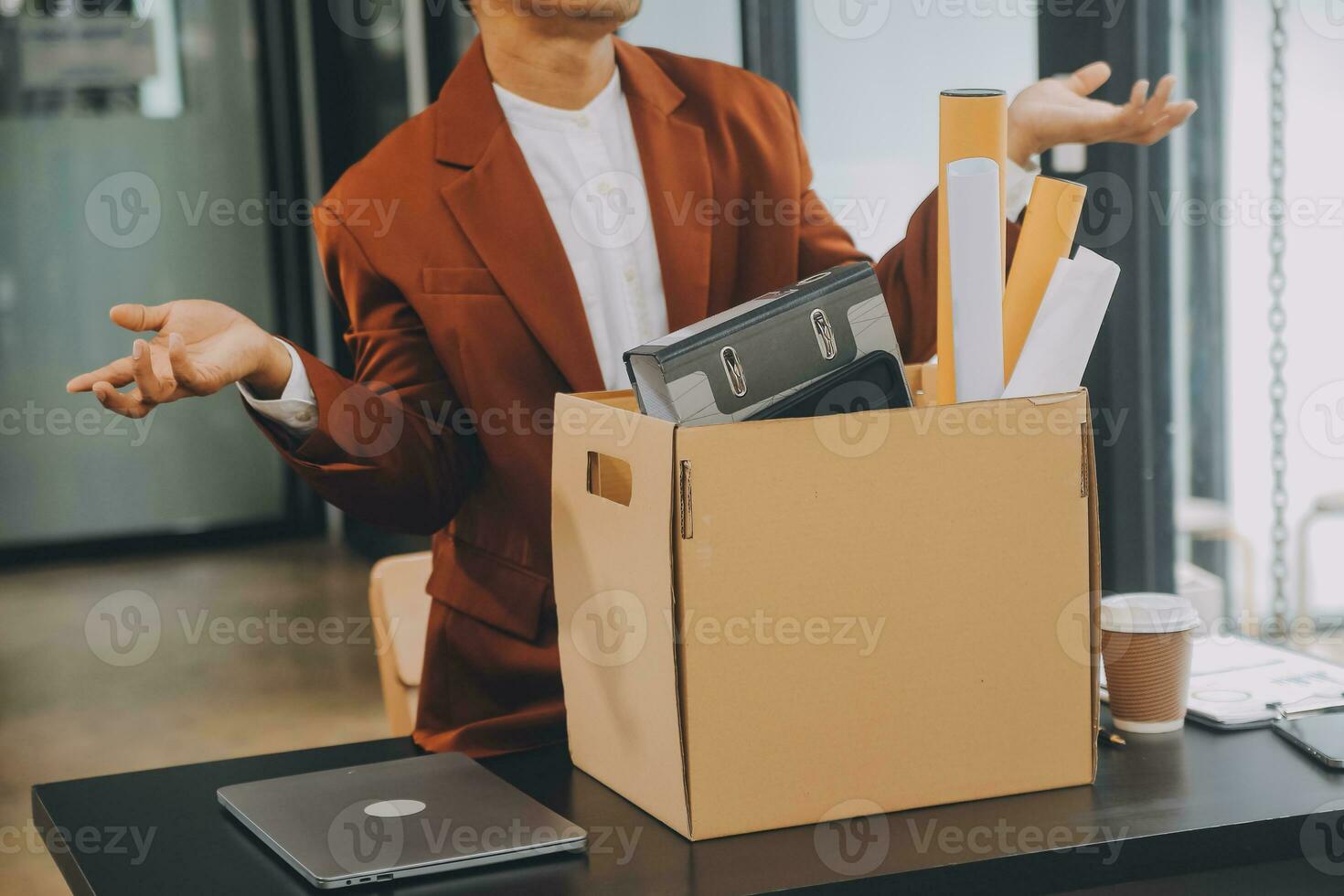 Business man employee stressful resignation from job while picking up personal belongings into brown cardboard box and carrying to walking out from office photo