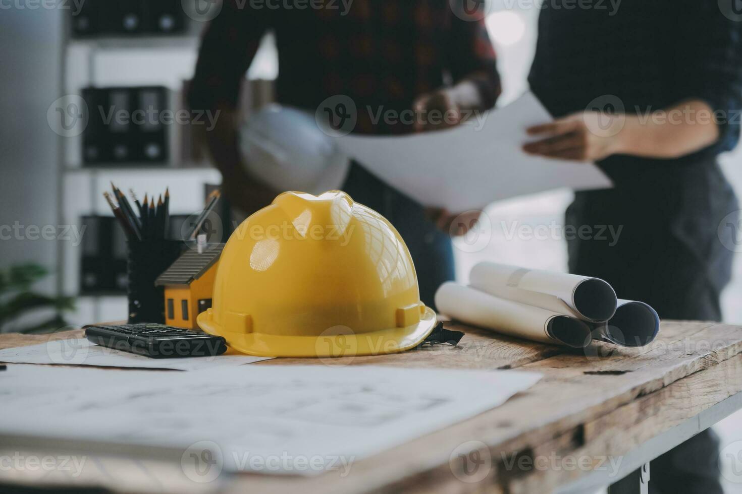 Close up of civil male engineer asian working on blueprint architectural project at construction site at desk in office. photo
