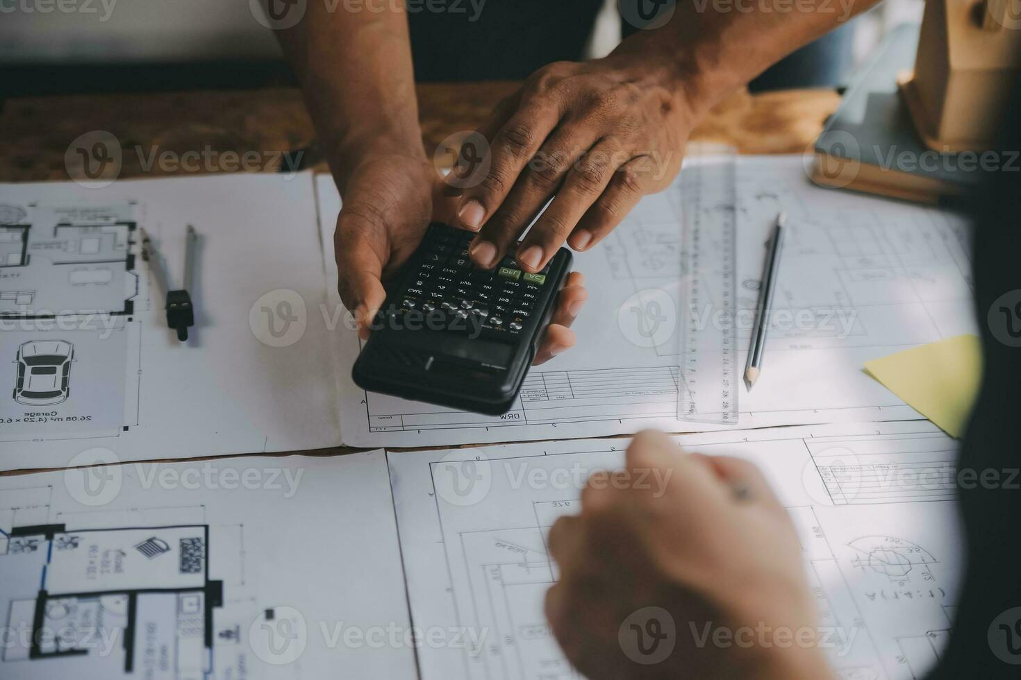 Close up of civil male engineer asian working on blueprint architectural project at construction site at desk in office. photo