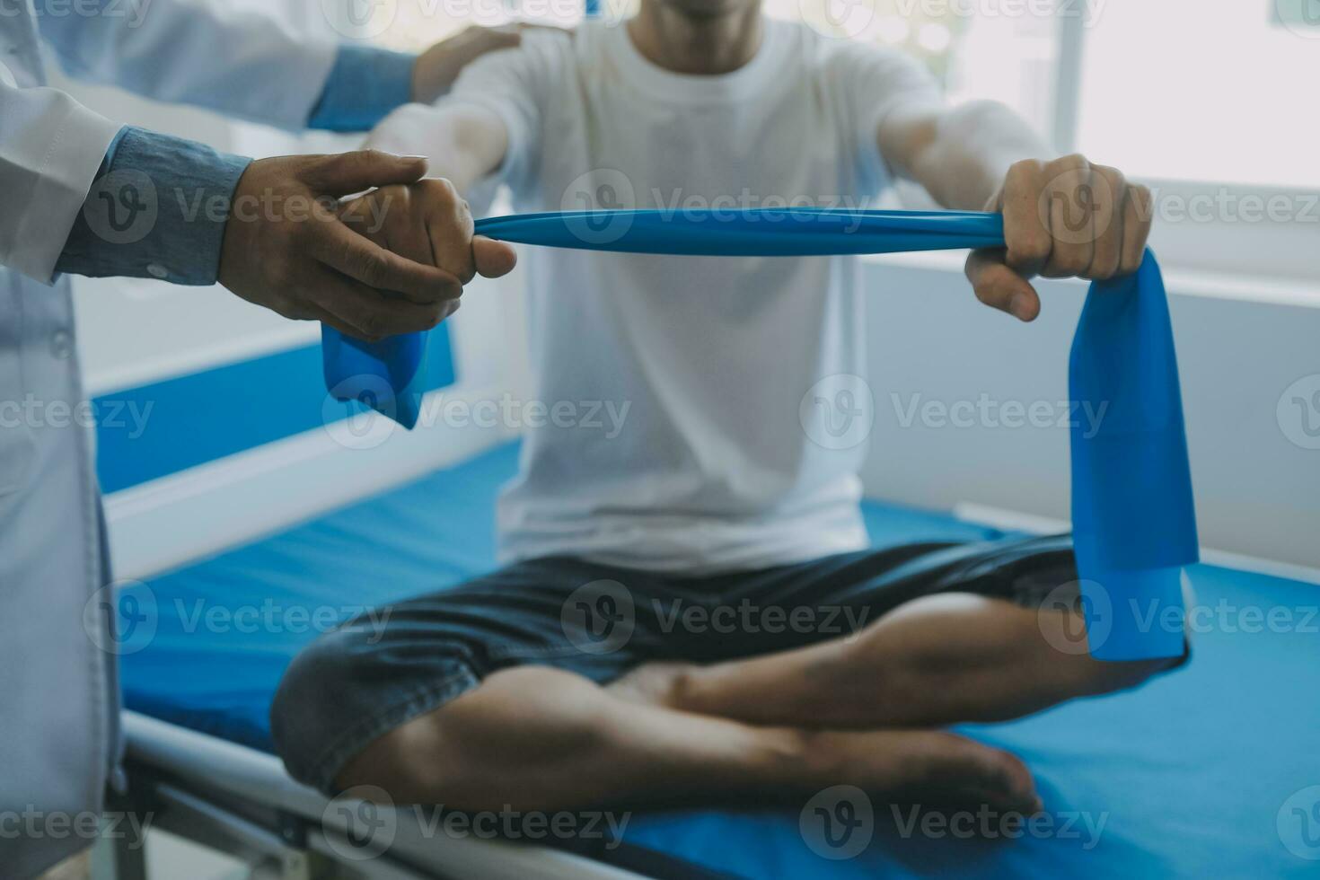 Doctor or physical therapist examines back pain and spinal area to give advice within the rehabilitation center. photo
