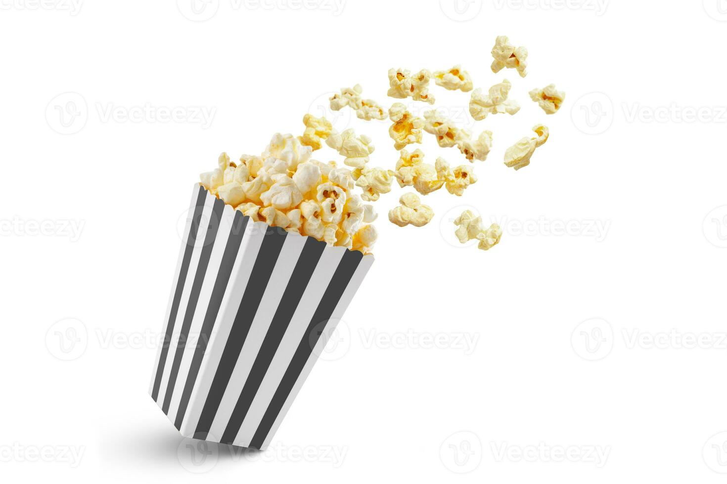 Popcorn flying out of black white striped paper box, isolated on white background photo