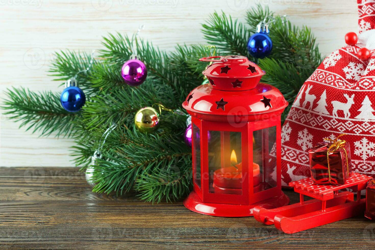 Lantern and Christmas tree over snow on wooden background photo