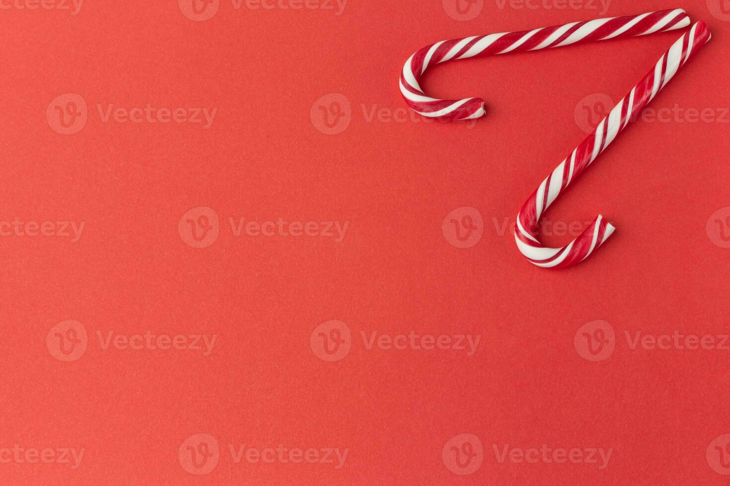 two red candy canes on red background photo