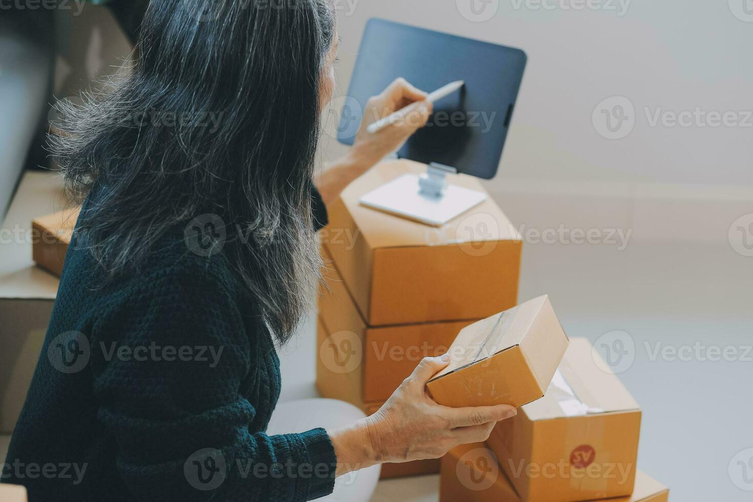 Startup SME small business entrepreneur of freelance Asian woman using a laptop with box Cheerful success Asian woman her hand lifts up online marketing packaging box and delivery SME idea concept photo