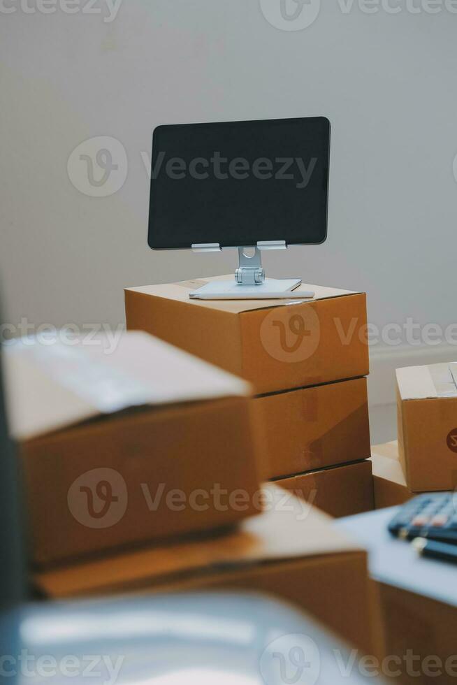 Entrepreneurs Small Business SME Independent men work at home Use smartphones and laptops for commercial checking, online marketing, packing boxes, SME sellers, concept, e-commerce team, online sales photo