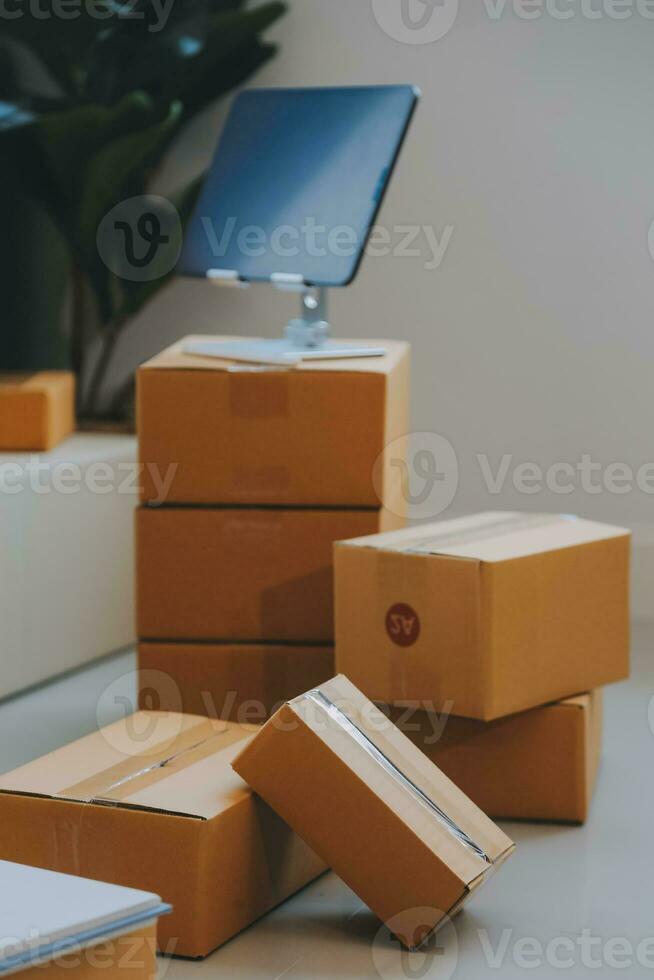 Entrepreneurs Small Business SME Independent men work at home Use smartphones and laptops for commercial checking, online marketing, packing boxes, SME sellers, concept, e-commerce team, online sales photo