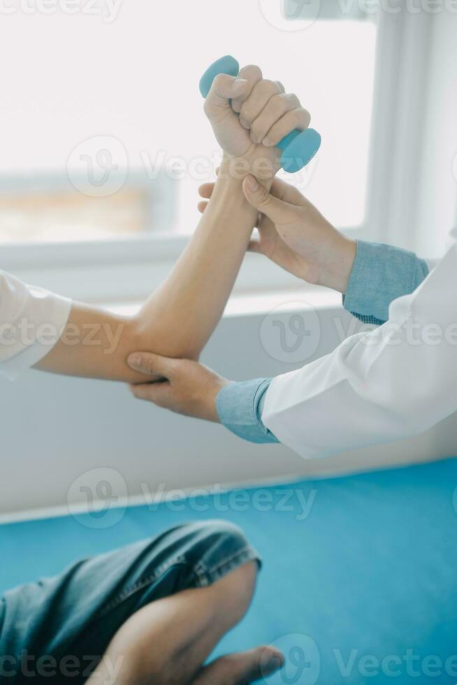 Doctor or physical therapist examines back pain and spinal area to give advice within the rehabilitation center. photo