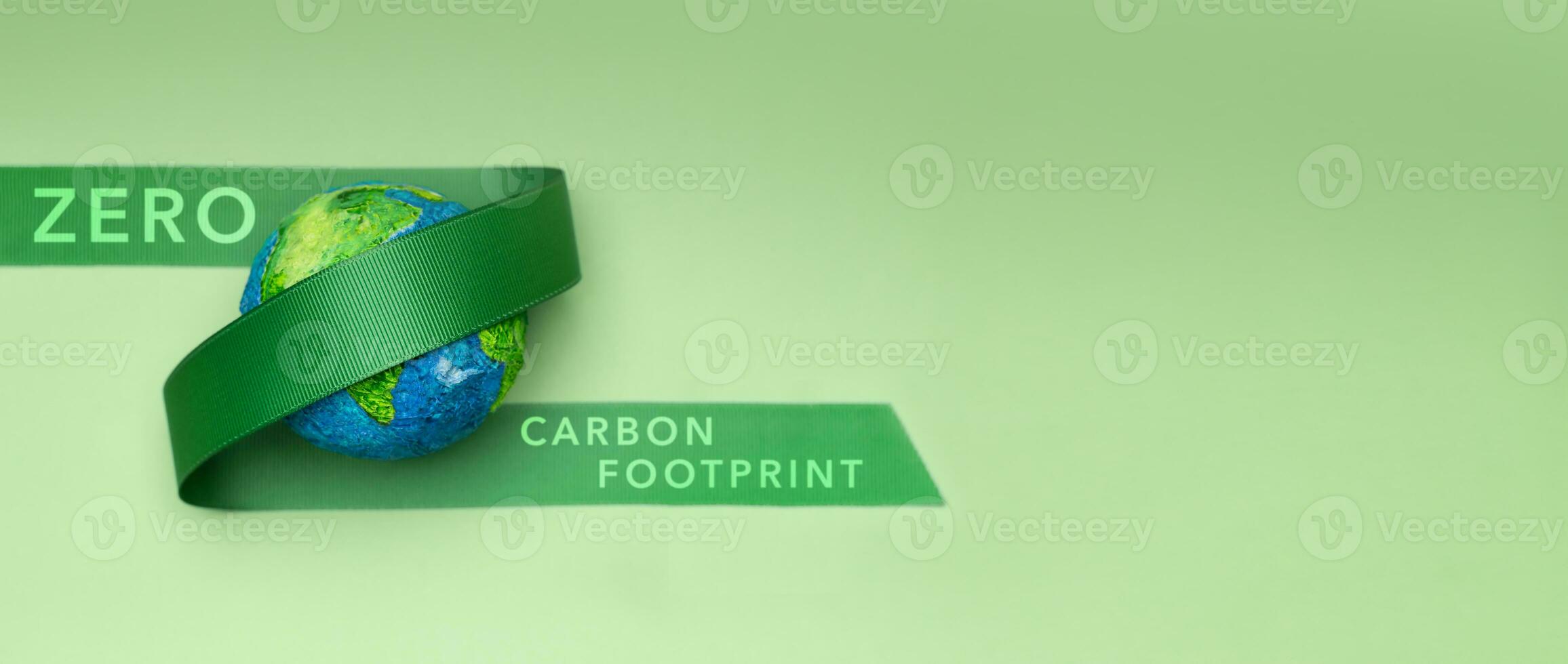 mundo tierra día concepto. cero carbón huella, esg, renovable y sostenible recursos. ambiental cuidado. verde cinta abrazando un globo. parte superior ver foto