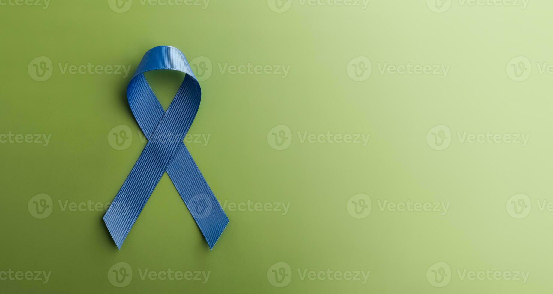 Prostate Cancer Awareness Campaign Concept. Men Healthcare. Close up of a Blue Ribbon Lying on Green background, Top View photo