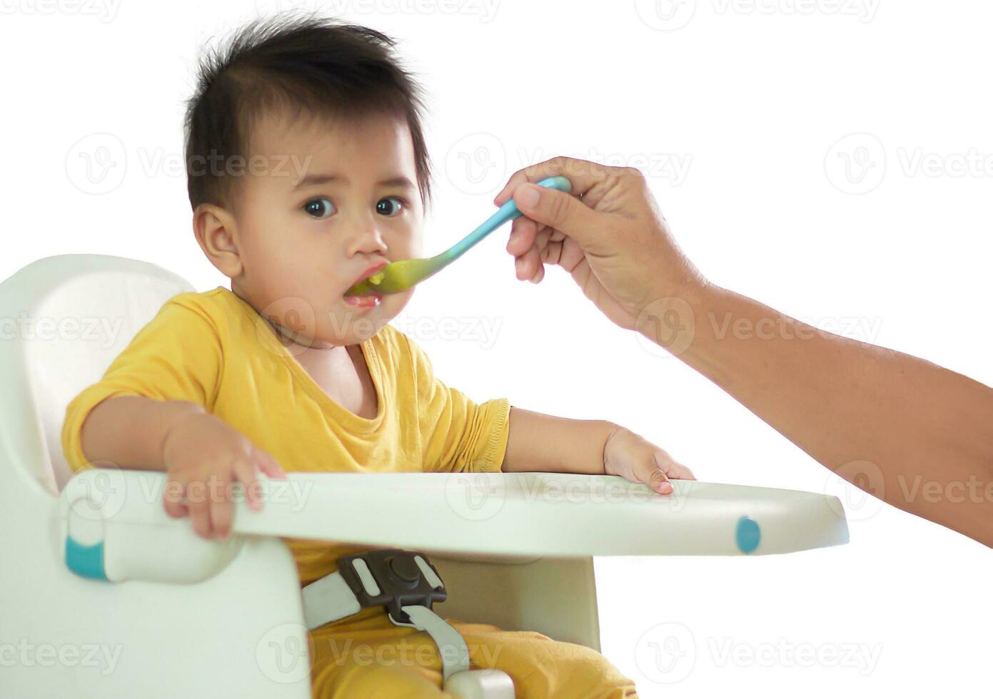 Cute white girl sitting chair eating breakfast in indoor home feeding delicious meals that are highly nutritious the baby has a cheerful face funny smiling and happy in a healthy family lifestyle. photo