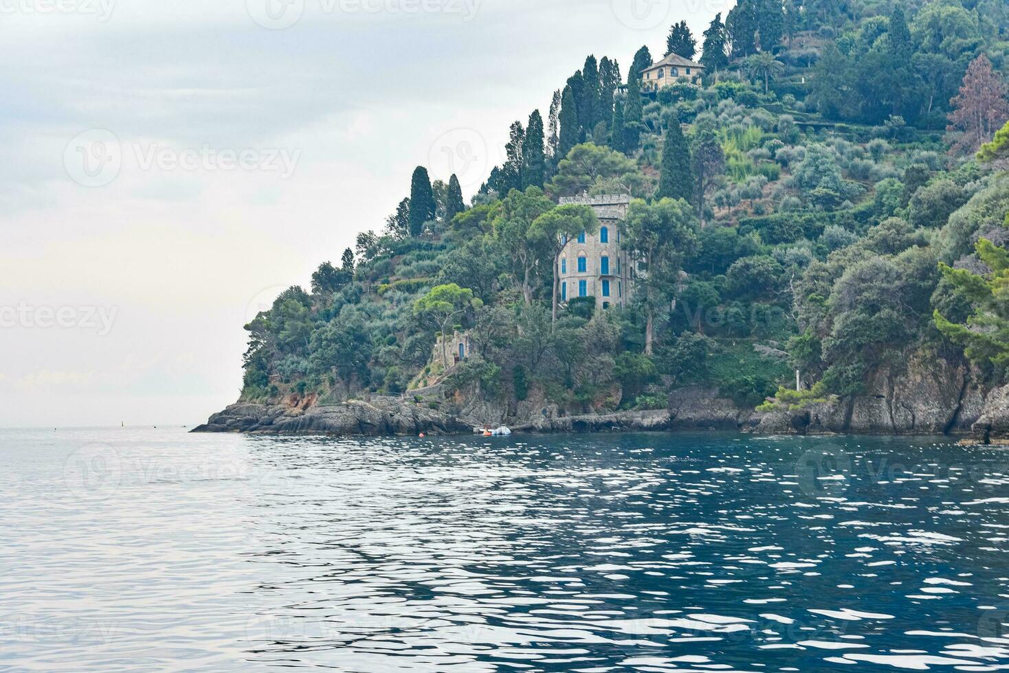 Yacht and boat on the sea and beautiful old villa on the cliff in Portofino, Italy. photo