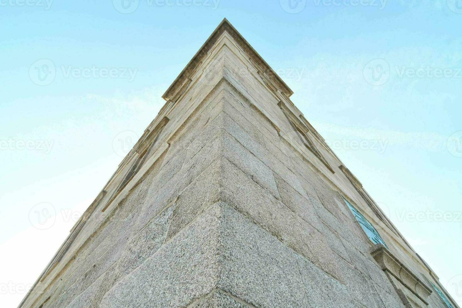 the top of a tall stone building with a clock on it photo