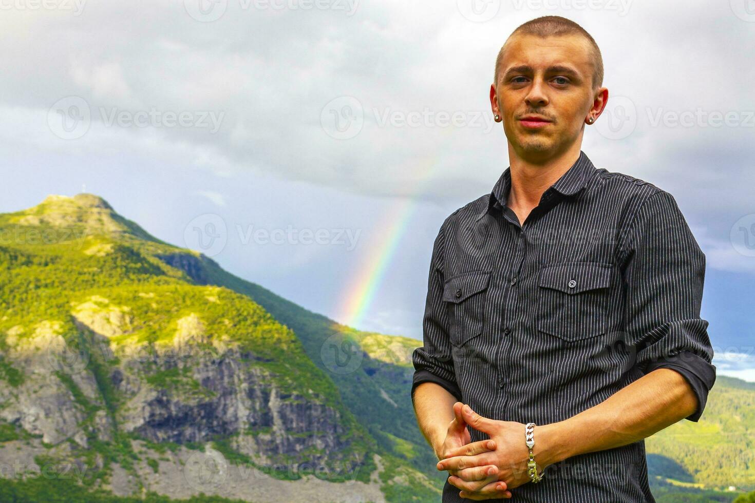 joven hombre modelo posando en frente de montaña arco iris Noruega. foto