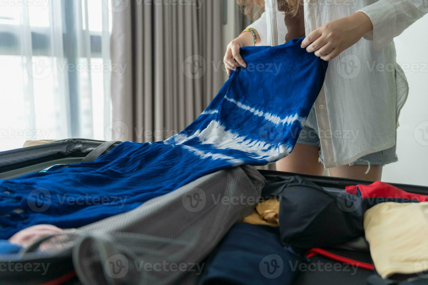 Woman packing suitcase on bed for a new journey packing list for travel planning preparing vacation Book Now Traveling Transportation photo