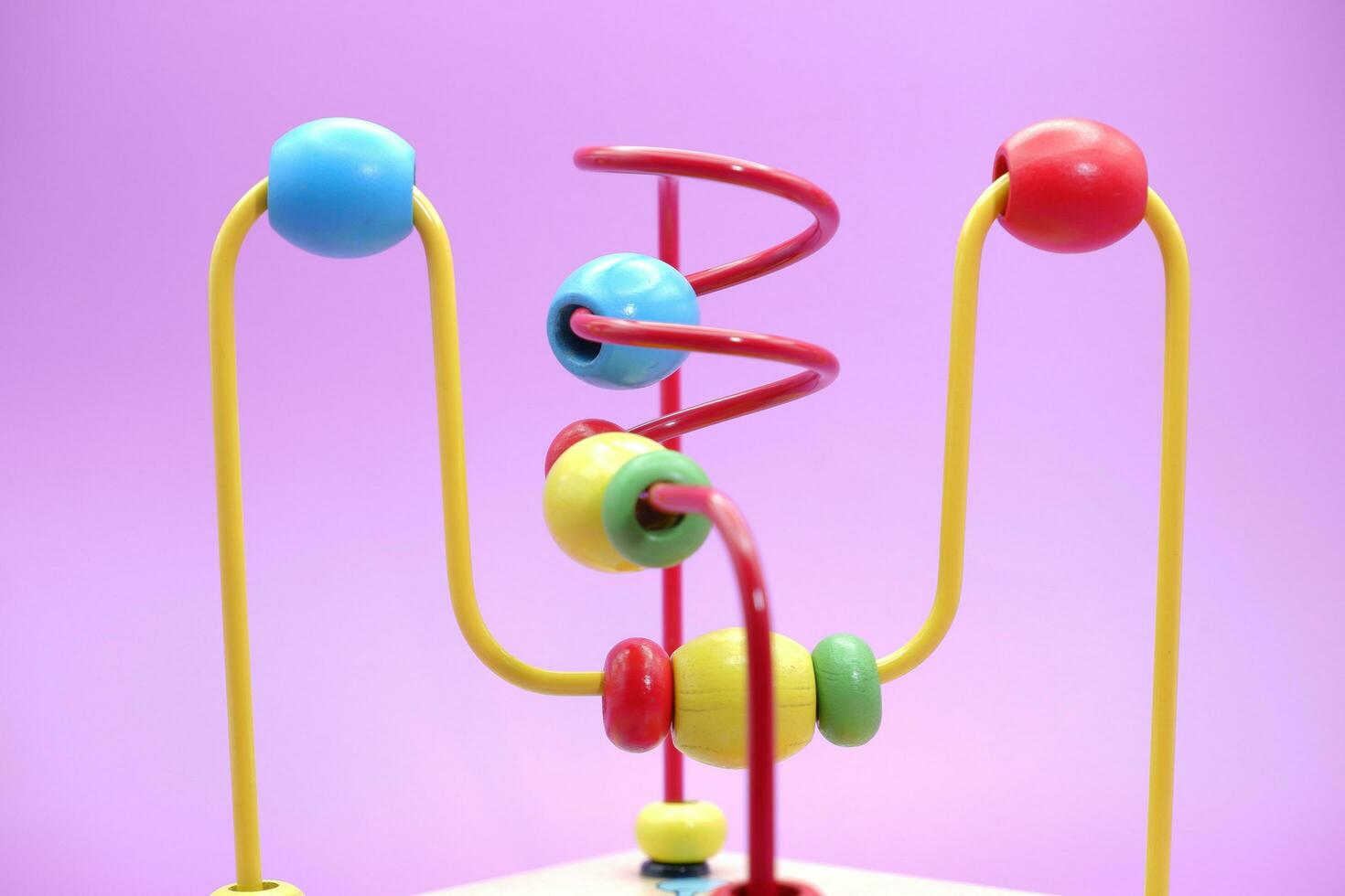 Children's educational toy isolated on purple background. toddler toys. toys with iron wire and beads. photo