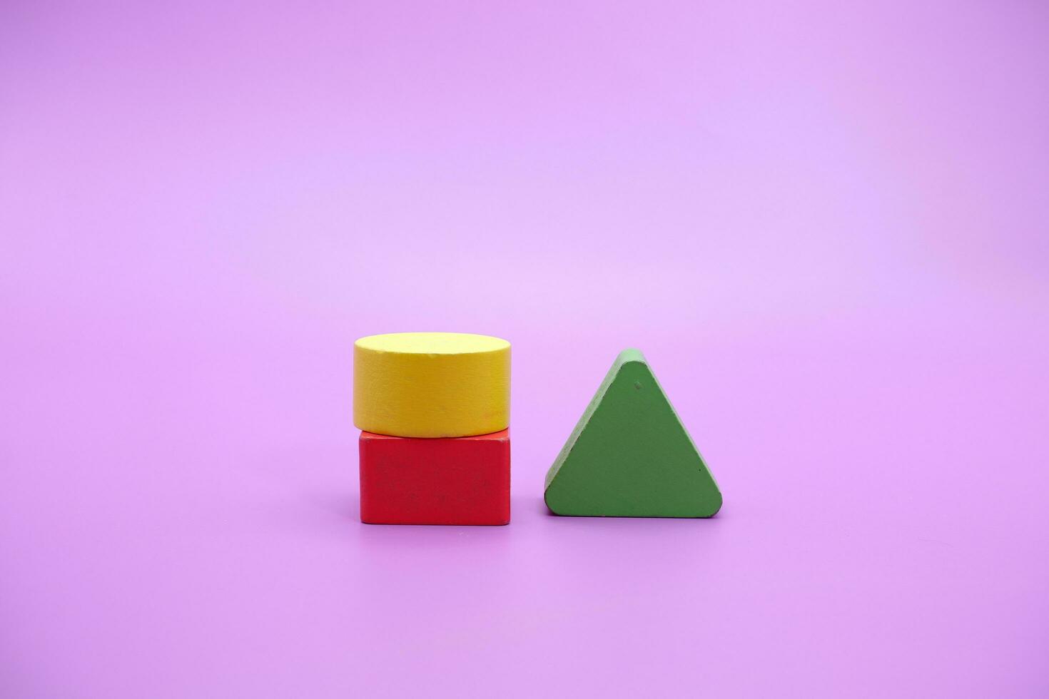 Set of colorful wooden shape toy. Square, triangle and round on Purple background photo