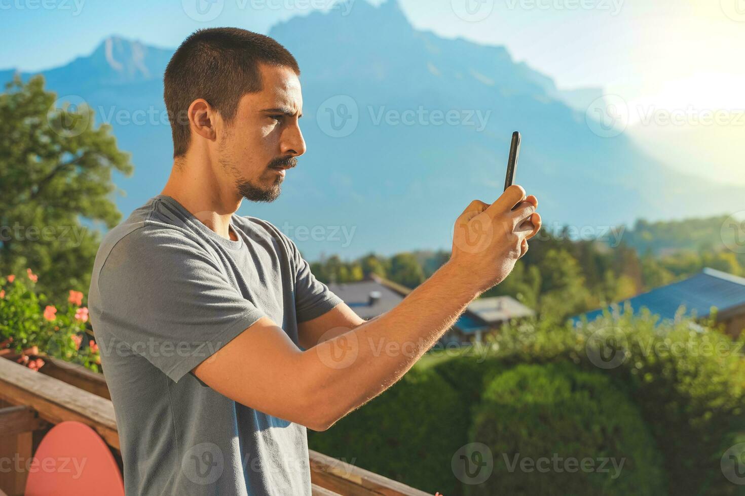 Young man taking a picture of a beautiful scenic mountain background. Attractive Traveler. photo