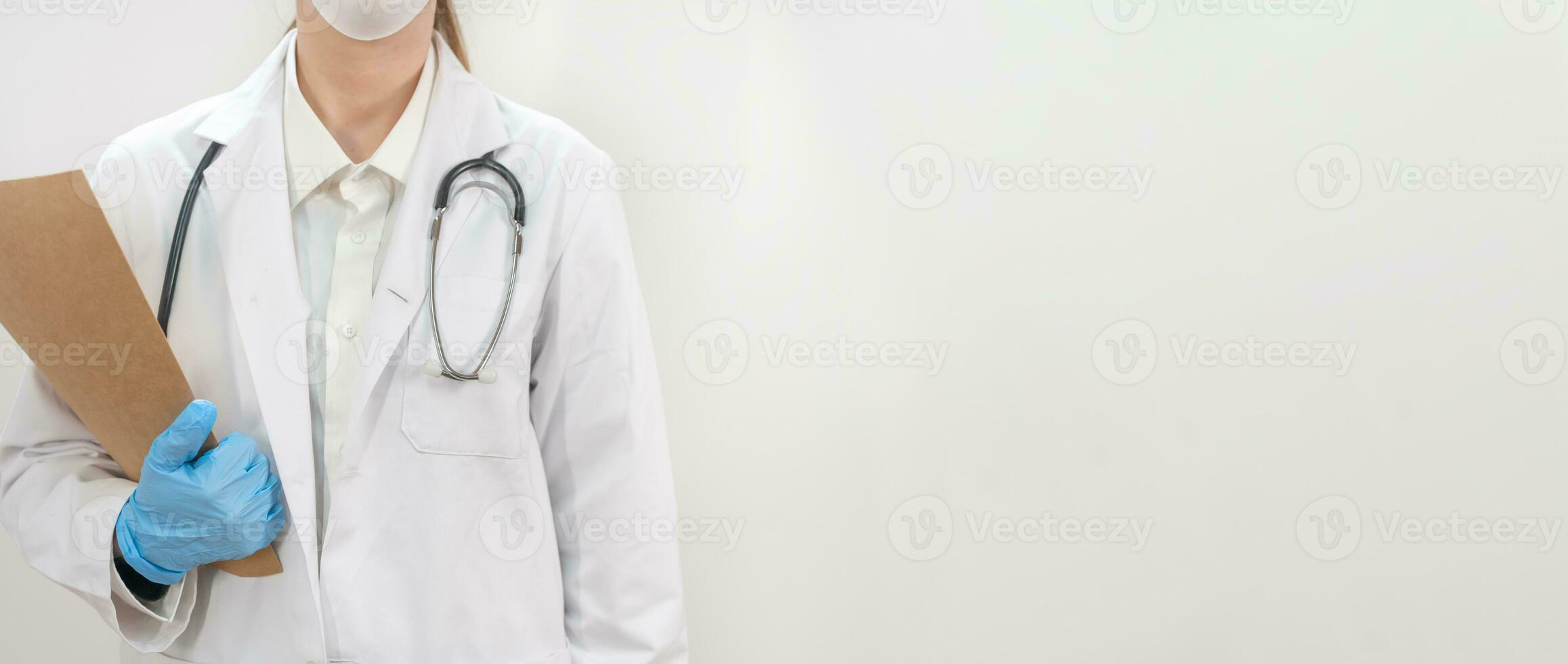 Banner with young attractive female doctor wearing blue gloves and blur hospital in the background. photo