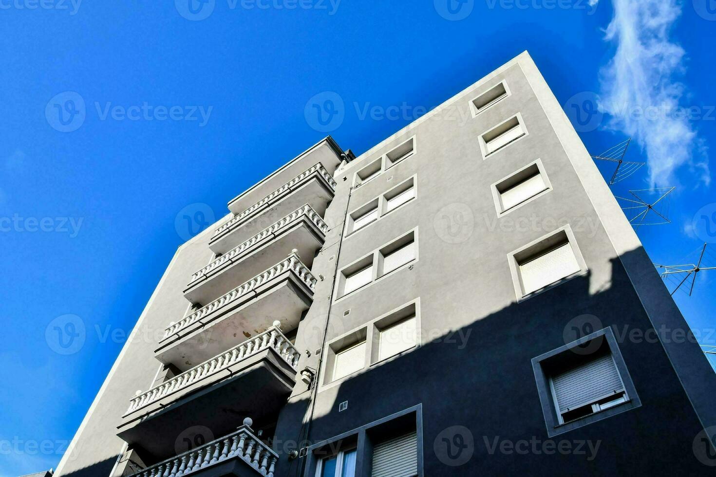 a tall building with balconies against a blue sky photo