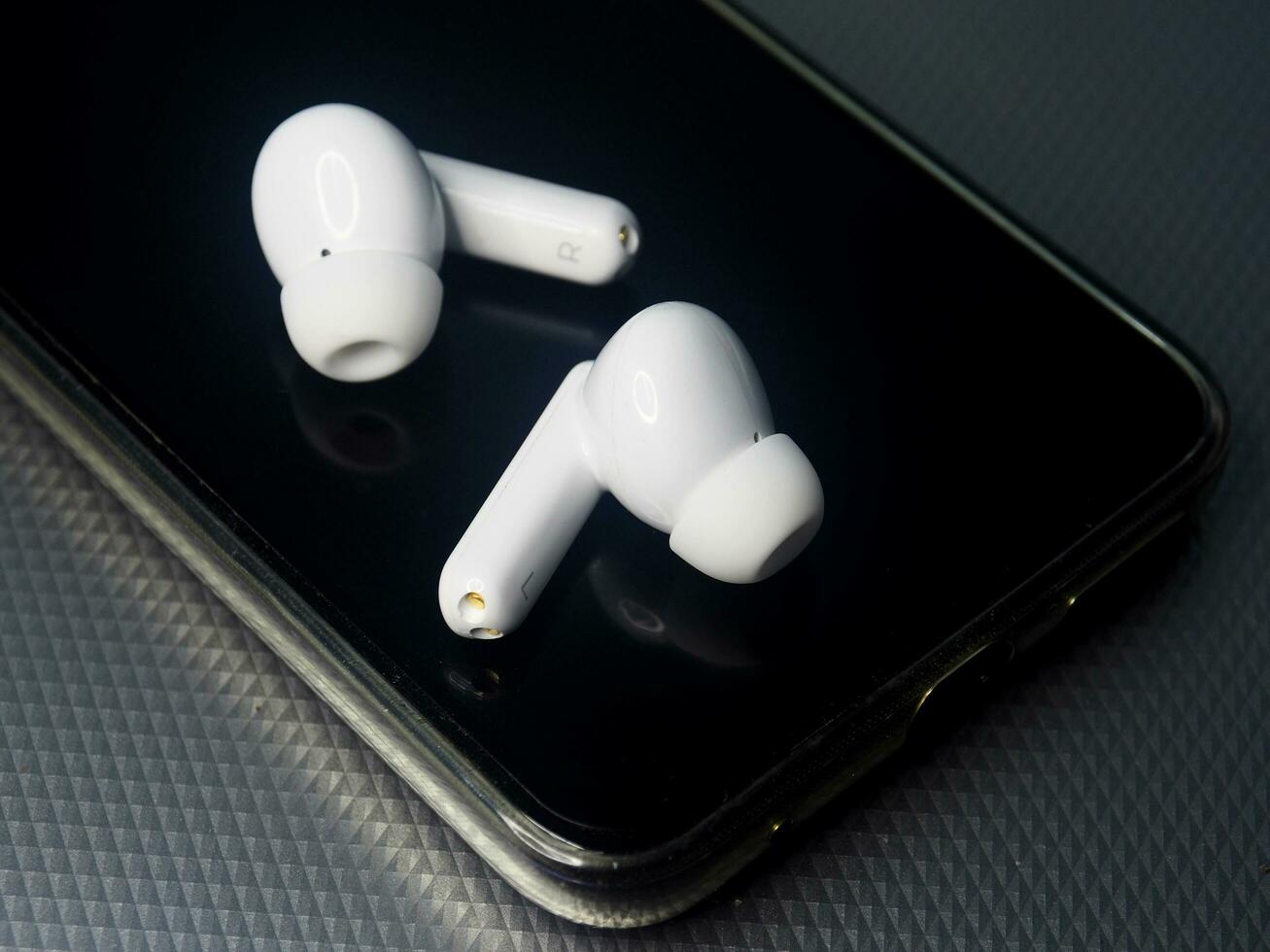 white earbuds and smart phone connect together photo