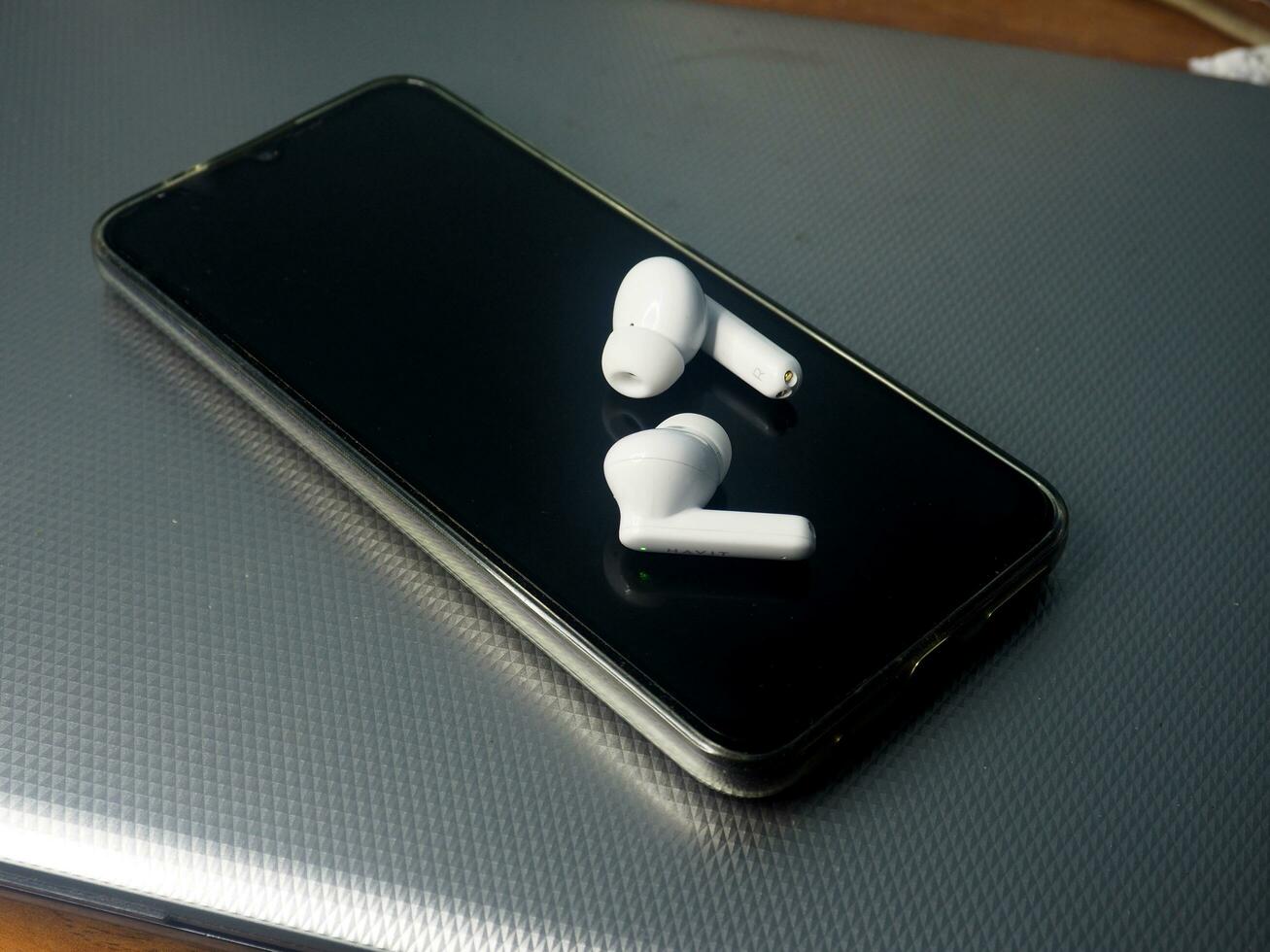white earbuds and smart phone connect together photo