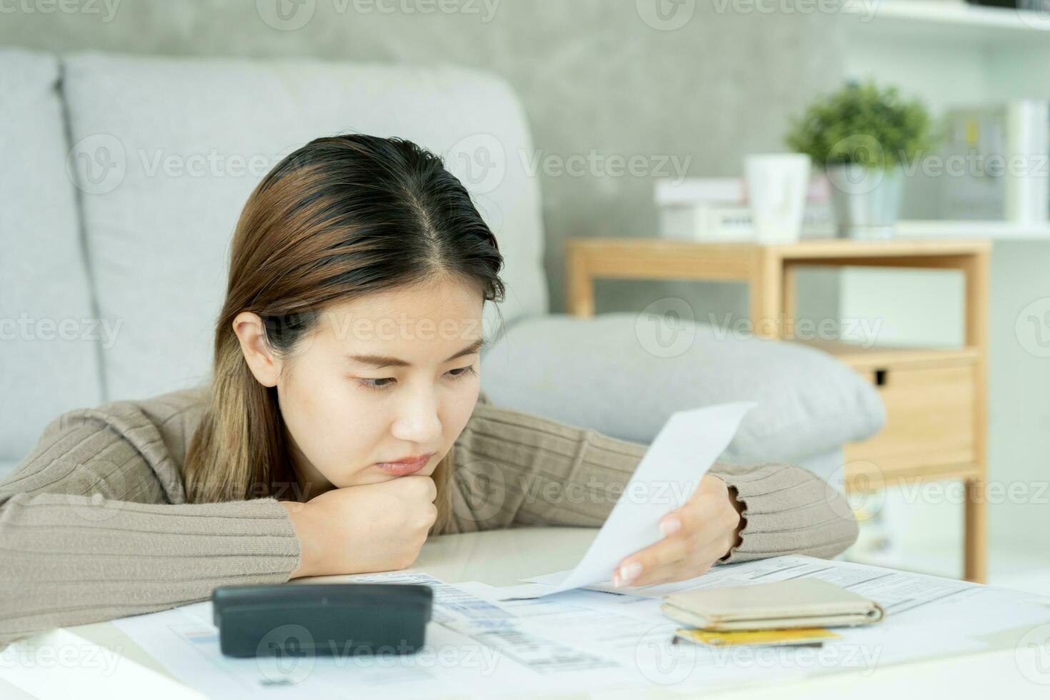 Stressed and headache asian woman with large bills or invoices no money to pay to expenses and credit card debt. shortage, Financial problems, mortgage, loan, bankruptcy, bankrupt, poor, empty wallet photo