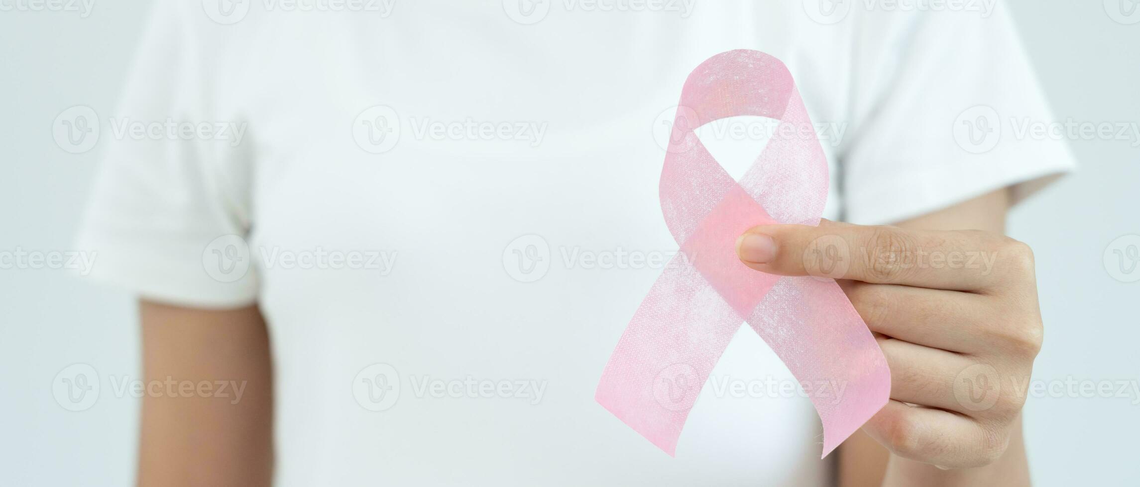 Woman hold pink ribbon breast cancer awareness. Female health check consciousness. international Women Day and World Cancer Day. sign cancer, Symbolic, health care, support patients, timely diagnosis photo