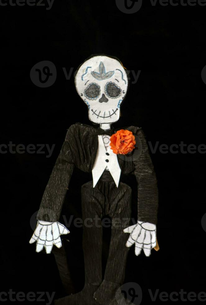 Craft of catrin or skull dressed as an elegant man with cempasuchil flower photo