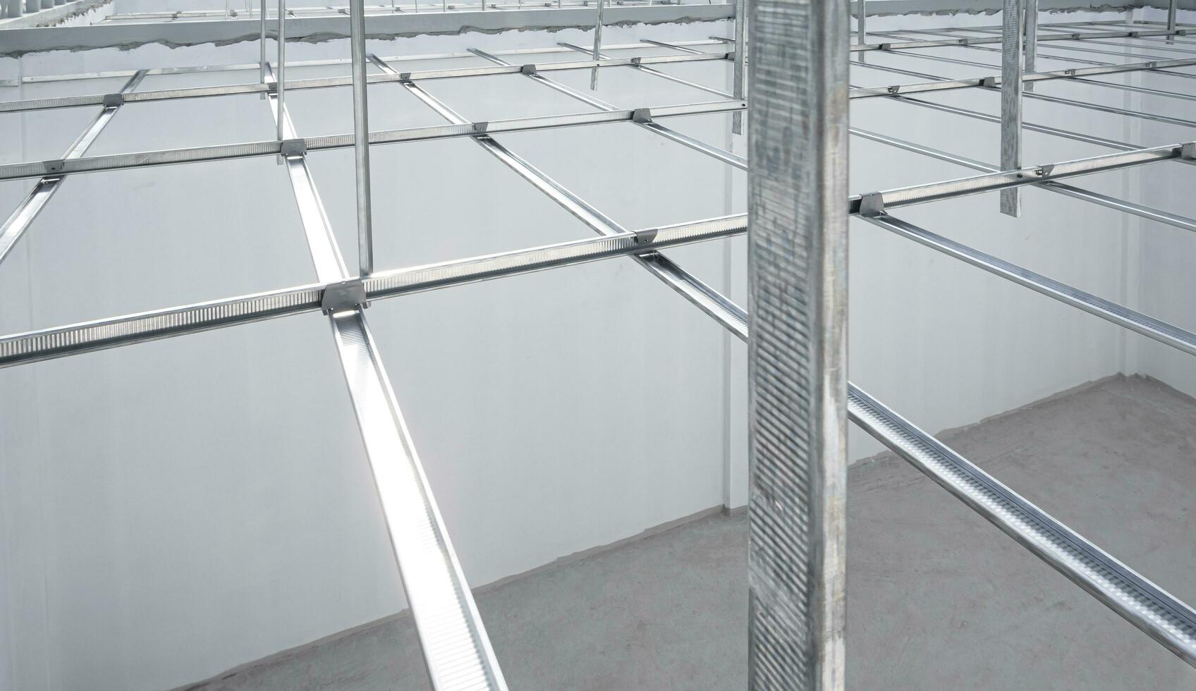 Aluminum c-line ceiling structure over white concrete wall in house construction site, high angle and perspective view photo